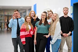 Eine Gruppe von Auszubildenen des SKK steht im Flur des Bildungszentrums und blickt fröhlich in die Kamera.