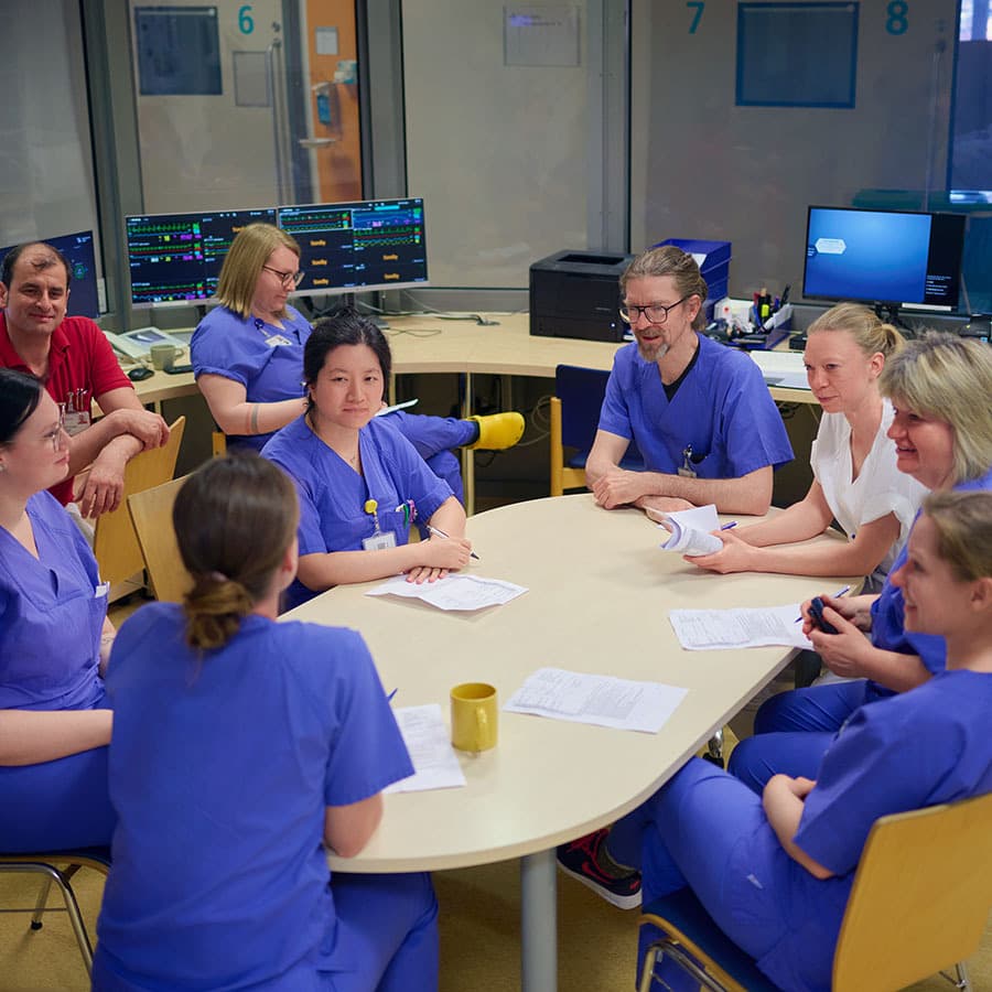 Das Team der Intensivstation sitzt in einem Besprechnungsraum und stimmt sich zum Tagesablauf auf der Station ab.