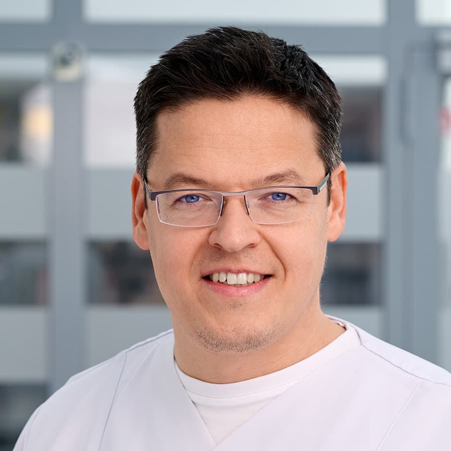 Doktor André Krath, Leiter der Unfallchirurgischen Abteilung am Städtischen Krankenhaus in Kiel, lächelt in die Kamera.